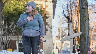 A protester stands next to a makeshift memorial honoring the victim of a fatal shooting involving federal law enforcement agents, near the scene in Minneapolis, Wednesday, Jan. 7, 2026. (AP Photo/Tom Baker) (AP) A protester stands next to a makeshift memorial honoring the victim of a fatal shooting involving federal law enforcement agents, near the scene in Minneapolis, Wednesday, Jan. 7, 2026. (AP Photo/Tom Baker) (AP)
