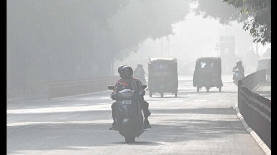 Commuters on their way during foggy weather on Thursday afternoon in Chandigarh. (Keshav Singh/HT)