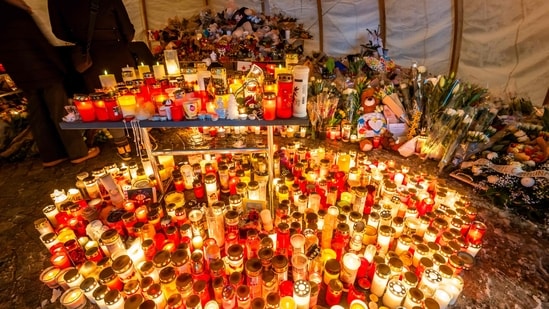 Attendees gather in mourning, placing messages, candles, and flowers at a memorial site in front of the bar �Le Constellation� during a national day of mourning in Crans-Montana, on January 9, 2026, in tribute to the victims of the fire that ravaged the bar on New Year�s Eve, killing 40 people and injuring 116 others, most of them teenagers. (AFP)