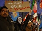 An anti-Iranian regime protester holds up a placard during a gathering outside the Iranian Embassy, central London, on January 9, 2026. 
