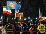 Anti-Iranian regime protesters hold up a portrait of Iranian opposition leader and son of the last shah of Iran Mohammad Reza Pahlavi, Reza Pahlavi (C), as they take part in a demonstration outside the Iranian Embassy in central London.