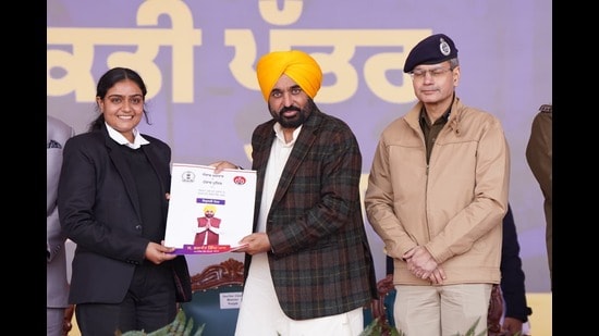 Punjab chief minister Bhagwant Mann handing over appointment letter to a newly recruited Punjab Police constable in Jalandhar on Sunday. (HT)
