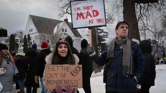 MINNEAPOLIS, MINNESOTA - JANUARY 10: EDITOR'S NOTE: Image contains profanity. Demonstrators hold signs with quotes as they participate in a march past the site where Renee Good was killed on January 10, 2026 in Minneapolis, Minnesota. The quote on the right are words spoken by Renee Good to an immigration enforcement agent moments before she was fatally shot on January 7. The quote on the left is from the response by Minneapolis Mayor Jacob Frey following the shooting to the roughly 2,000 immigration enforcement agents sent to the city by the Trump administration. Scott Olson/Getty Images/AFP (Photo by SCOTT OLSON / GETTY IMAGES NORTH AMERICA / Getty Images via AFP)(Getty Images via AFP)