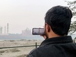 A man clicks a picture of the Taj Mahal at the Taj Viewpoint as a thick layer of fog engulfs the monument amid intensifying cold, in Agra on Sunday. (ANI Video Grab) A man clicks a picture of the Taj Mahal at the Taj Viewpoint as a thick layer of fog engulfs the monument amid intensifying cold, in Agra on Sunday. (ANI Video Grab)