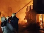 Firemen dousing the blaze that broke out near the old bus stand of Arki town of Solan district early on Monday. (HT Photo)