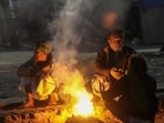 New Delhi: People sit around a small fire to keep themselves warm on a winter evening (PTI)