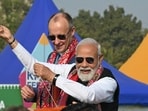 Prime Minister Narendra Modi (R) flies a kite alongside German Chancellor Friedrich Merz