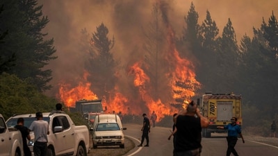 TOPSHOT - Firefighters battle the flames to extinguish a bushfire in Mount Pirque at El Hoyo, in the Patagonian region of Chubut province, Argentina on January 10, 2026. More than 5,500 hectares of forest have been consumed by the main wildfire in Argentina's Patagonia, as hundreds of firefighters and local volunteers struggled to contain flames out of control that have left small communities on edge. The blazes come a year after Patagonia suffered its worst wildfires in three decades, part of a string of extreme events that has kept official and community firefighting systems under constant strain. (Photo by Gonzalo KEOGAN / AFP) (AFP) TOPSHOT - Firefighters battle the flames to extinguish a bushfire in Mount Pirque at El Hoyo, in the Patagonian region of Chubut province, Argentina on January 10, 2026. More than 5,500 hectares of forest have been consumed by the main wildfire in Argentina's Patagonia, as hundreds of firefighters and local volunteers struggled to contain flames out of control that have left small communities on edge. The blazes come a year after Patagonia suffered its worst wildfires in three decades, part of a string of extreme events that has kept official and community firefighting systems under constant strain. (Photo by Gonzalo KEOGAN / AFP) (AFP)