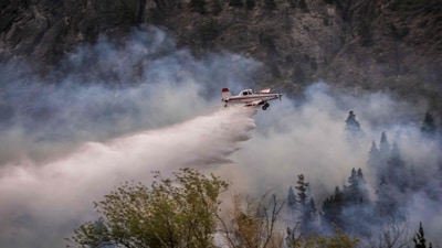 TOPSHOT - An aircraft sprays water to extinguish a bushfire in Mount Pirque at El Hoyo, in the Patagonian region of Chubut province, Argentina on January 10, 2026. More than 5,500 hectares of forest have been consumed by the main wildfire in Argentina's Patagonia, as hundreds of firefighters and local volunteers struggled to contain flames out of control that have left small communities on edge. The blazes come a year after Patagonia suffered its worst wildfires in three decades, part of a string of extreme events that has kept official and community firefighting systems under constant strain. (Photo by Gonzalo KEOGAN / AFP) (AFP) TOPSHOT - An aircraft sprays water to extinguish a bushfire in Mount Pirque at El Hoyo, in the Patagonian region of Chubut province, Argentina on January 10, 2026. More than 5,500 hectares of forest have been consumed by the main wildfire in Argentina's Patagonia, as hundreds of firefighters and local volunteers struggled to contain flames out of control that have left small communities on edge. The blazes come a year after Patagonia suffered its worst wildfires in three decades, part of a string of extreme events that has kept official and community firefighting systems under constant strain. (Photo by Gonzalo KEOGAN / AFP) (AFP)