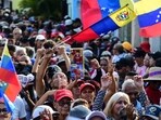 A demonstrator holds a toy of the caped superhero named "Super-Bigote" (Super-Mustache) during a rally in support of ousted Venezuela's President Nicolas Maduro in Valencia, Carabobo state, Venezuela 