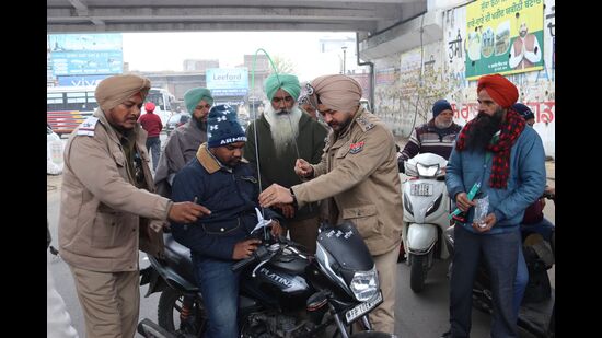 Police officials installing wire shield on a bike in Mandi Mullapur, Ludhiana, on Tuesday.