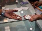 A saleswoman shows a silver coin to a customer in Guwahati. A saleswoman shows a silver coin to a customer in Guwahati.