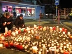 People lay candles near the Le Constellation bar, where a devastating fire left dead and injured during the New Year's celebrations in Crans-Montana, Swiss Alps, Switzerland, Thursday, Jan. 1, 2026.