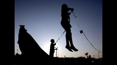 Two boys are silhouetted as they fly a kite (File)