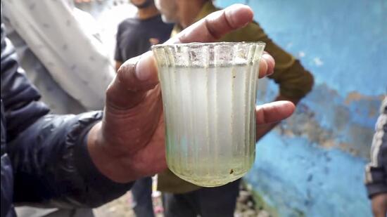 A man holds a glass of contaminated tap water at Bhagirathpura in Indore on January 2. (PTI)