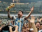 Lionel Messi celebrates with the World Cip trophy.