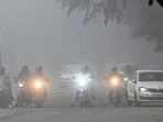 Motorists use headlights during the day amid dense fog in Chandigarh on Wednesday. (Keshav Singh/HT)