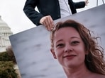 An aide collects a photo of Renee Good, who was shot and killed in Minneapolis on January 7 