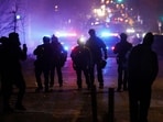 Federal agents stand guard as community members protest after federal law enforcement agents were involved in a shooting incident, a week after a U.S. Immigration and Customs Enforcement (ICE) agent fatally shot Renee Nicole Good, in Minneapolis, Minnesota, U.S., January 14, 2026. 