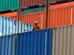 A worker sits on a ship carrying containers at Mundra port in Gujarat.