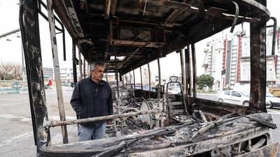 A man stands inside a burnt bus in Tehran. (AFP) A man stands inside a burnt bus in Tehran. (AFP)