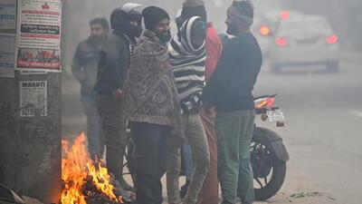 People stand close around a bonfire to stay warm on a cold winter morning in Gurugram. (Parveen Kumar/ HT Photo) People stand close around a bonfire to stay warm on a cold winter morning in Gurugram. (Parveen Kumar/ HT Photo)