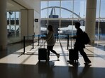 Passengers walk to a Transportation Security Administration (TSA) security checkpoint while traveling at Los Angeles International Airport (LAX).