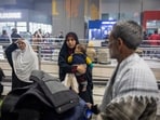 Indian citizen Shagufta Tanveer holds her son after arriving at Indira Gandhi International Airport on a commercial flight from Tehran. 
