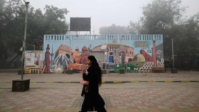 Gram it: Delhi skies might be foggy but its artsy murals still manage to add vibrancy in daily lives of commuters. Here's one such instance as a shutterbug captures a woman walking past a mural amid dense fog on Saturday morning. Can you identify this spot is the city? (Photo: Manan VATSYAYANA/AFP)