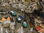 Police recover the bodies of people who died after wildfires swept through homes near Lirquen, Chile.