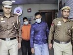 Cyber Police personnel with two of the eight accused arrested after an interstate investment fraud syndicate was busted in New Delhi on Sunday. (ANI video grab)