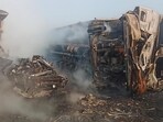 The mangled remains of the truck on KMP expressway as fire officials douse one of the engulfed truck. (HT Photo)