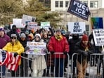 Anti-ICE protesters stand near City Hall with signs on January 17, 2026 in Minneapolis, Minnesota. (Photo by Jim Vondruska / GETTY IMAGES NORTH AMERICA / Getty Images via AFP)