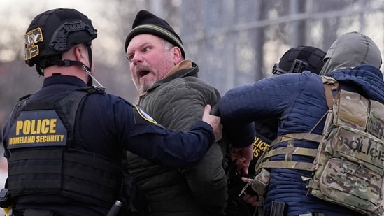 Law enforcement detain a man outside the Bishop Henry Whipple Federal Building during a protest on Saturday, Jan. 17, 2026, in Minneapolis. (AP Photo/Yuki Iwamura)(AP)