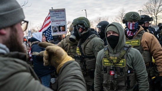 Demonstrators near federal law enforcement officers during a protest outside the Bishop Henry Whipple Federal Building in St. Paul, Minnesota, US, on Saturday, Jan. 17, 2026. (Photographer: Victor J. Blue/Bloomberg)(Bloomberg)