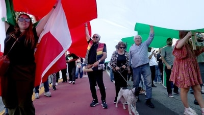 A group of people march under a giant flag in Los Angeles, California, U.S. January 18, 2026. Protesters in Iran have said that they feel Donald Trump has betrayed them after the US President reversed course and announced that Iran’s regime had agreed to stop killing its people in the streets. REUTERS/Jill Connelly (REUTERS)