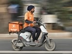 A food delivery worker for Swiggy rides an electic scooter in Bengaluru 