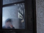 ChongLy "Scott" Thao's four-year-old grandson, (name withheld for security reasons), traces his finger in frozen condensation at the back door of the family home a day after Scott Thao was taken by US Immigration and Customs Enforcement (ICE) agents.