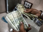 An employee counts 500 rupee banknotes at a currency exchange in New Delhi, India. An employee counts 500 rupee banknotes at a currency exchange in New Delhi, India.