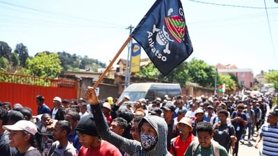 A protester carries a banner featuring a Malagasy version of the logo of the popular Japanese manga One Piece, a symbol adopted by Gen Z protest movements worldwide. He marches along with other protestors during a nationwide youth-led demonstration in Antananarivo, Madagascar, over frequent power outages and water shortages. (Reuters)