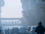 People are seen out during a hazy morning near Moti Bagh in New Delhi on Tuesday.