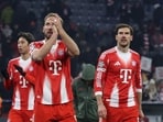 Bayern Munich's Harry Kane (C) and Leon Goretzka (R) celebrate after winning a match.