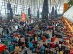 Stranded passengers searching for their luggage near a counter after IndiGo cancelled more than 400 flights at the airport in Bengaluru on December 5, 2025. This was one of many airports where the mass mess unfolded in that week. (PTI file photo)