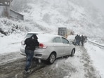 A commuter struggling to negotiate a slippery stretch after heavy snowfall in Shimla on Friday. (Deepak Sansta/HT)