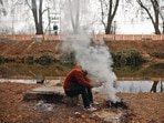 A man warms himself up next to a bonfire on the banks of Dal Lake in Srinagar on a chilly Thursday evening. (REUTERS) A man warms himself up next to a bonfire on the banks of Dal Lake in Srinagar on a chilly Thursday evening. (REUTERS)
