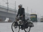 New Delhi, India - January 6, 2019: A milkman rides his bicycle during light rainfall, at Modi Mill flyover, in New Delhi, India, on Sunday, January 6, 2019. The national capital received its first rainfall of the year with the temperature taking a dip. (Photo by Burhaan Kinu / Hindustan Times) (Burhaan Kinu/HT PHOTO)