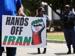 A protesters hold a poster during a solidarity protest outside the U.S. embassy for the people of Venezuela, Iran and Palestine, in Cape Town, South Africa.
