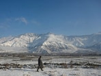 A man walks on snow covered field on the outskirts of Srinagar on Saturday. (Waseem Andrabi /HT)