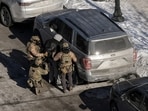 Federal agents detain a person at the scene where federal agents fatally shot a man