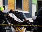Paramedics carry a man on a stretcher near the scene where federal agents fatally shot a man while trying to detain him